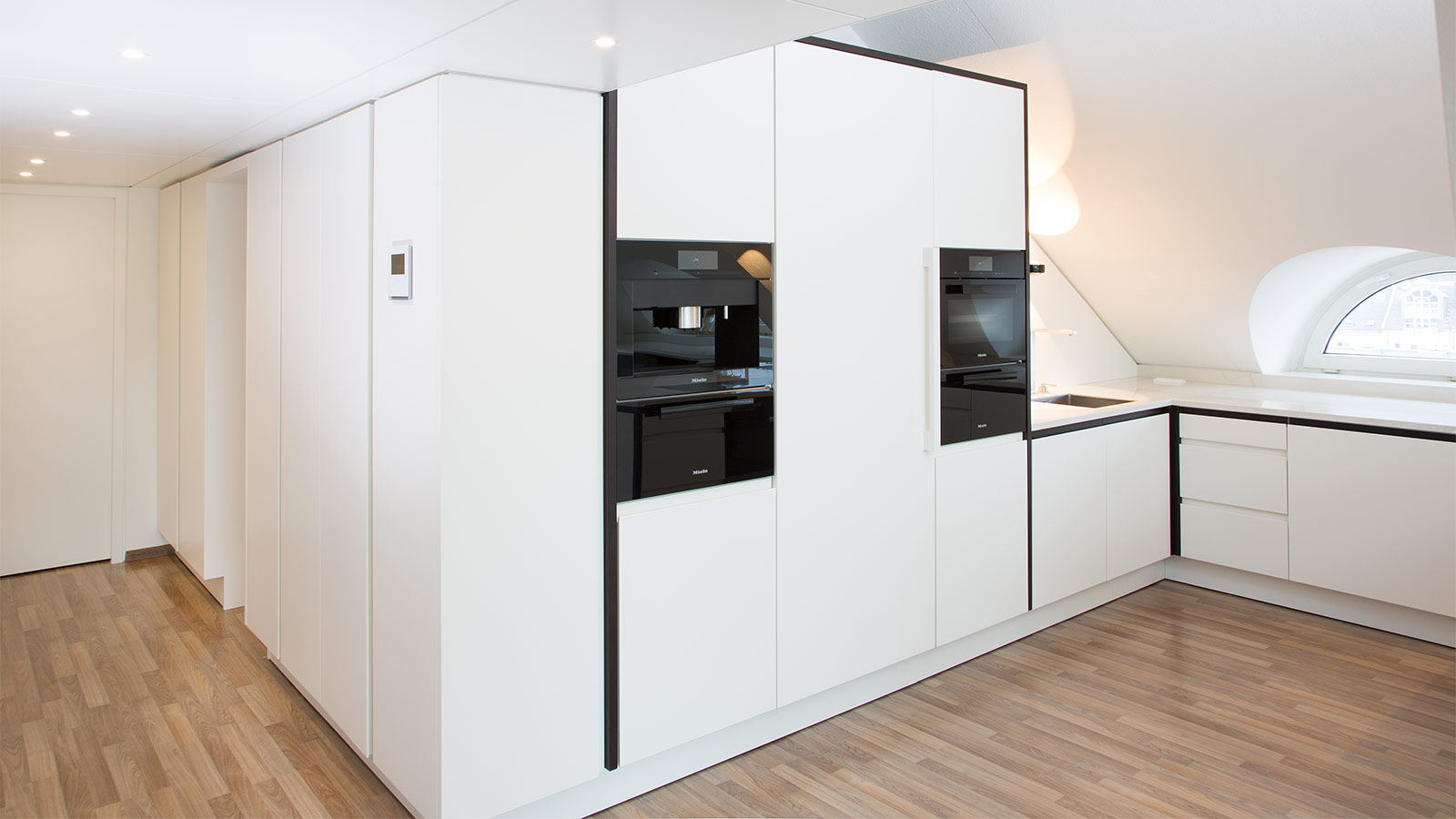 Loftküche in Köln mit Atmosphäre - Der Gangbereich wurde mit Einbauschränken verbaut